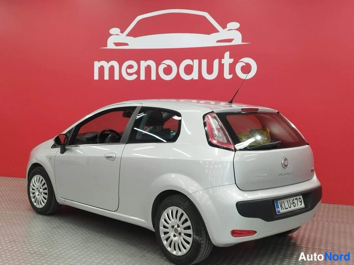 Takaviisto: Fiat Punto Evo takaviisto oikealta, rekisterikilpi, punaiset takavalot ja Fiat-merkki takaluukissa.