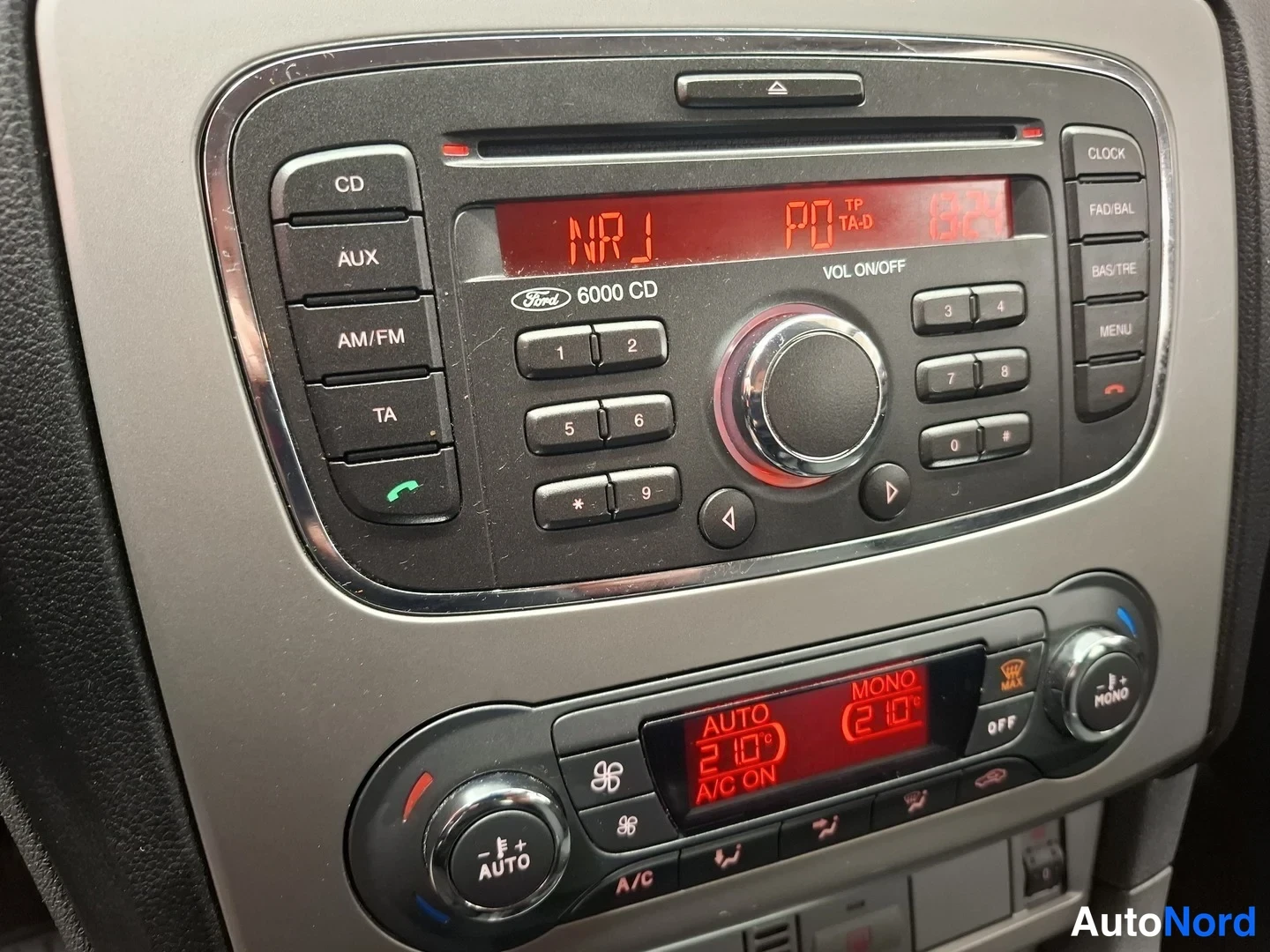 Muu: Keskiöudessa radio ja CD-soitin Ford-6000 CD-merkinnällä, alapuolella ilmastointipaneeli jossa AUTO ja A/C ON -tekstit.