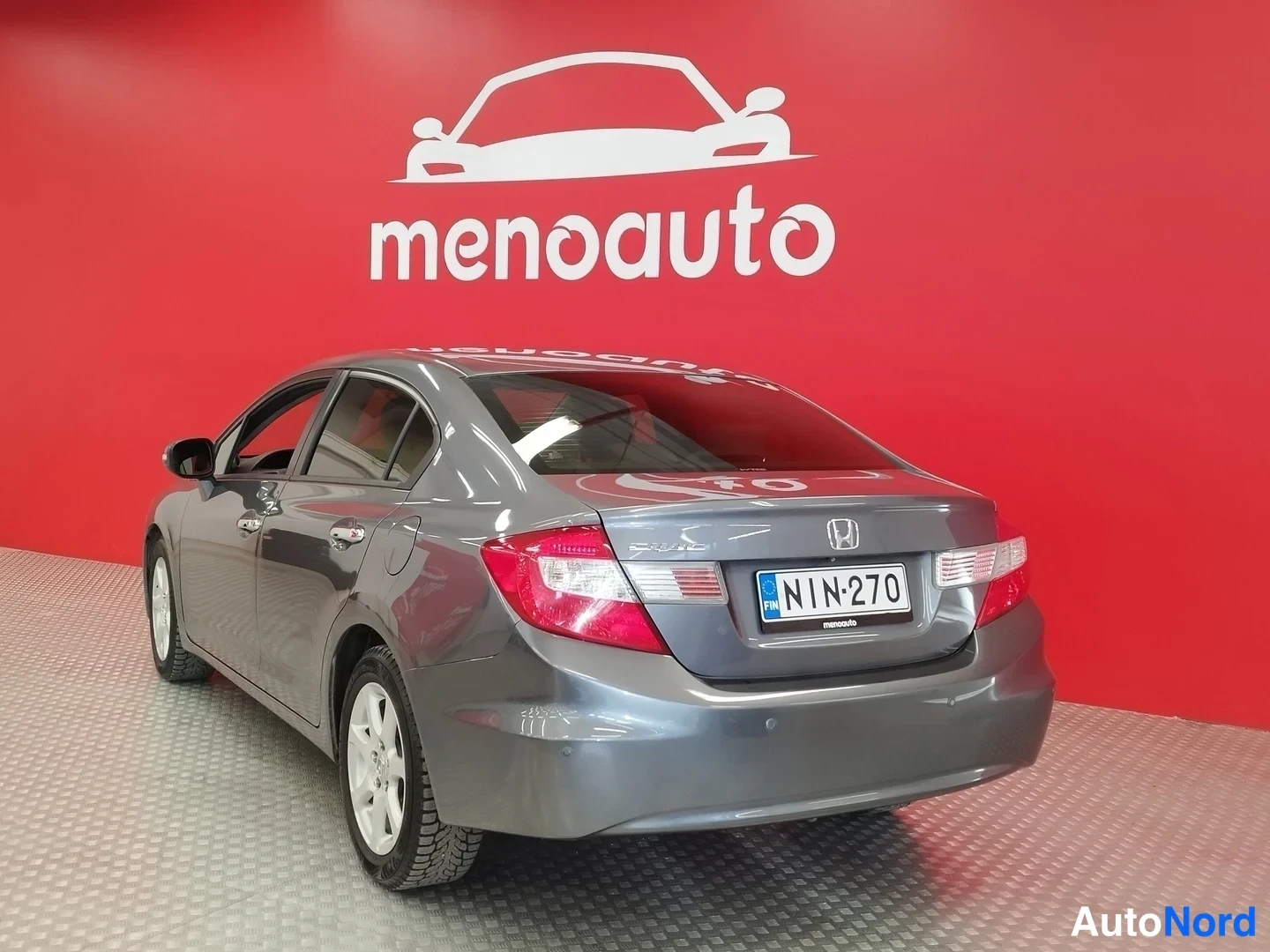 Takaviisto: Honda Civic -sedanin takakolmanneskulma; rekisterikilpi, Honda-merkki ja takavalojen osat näkyvät.