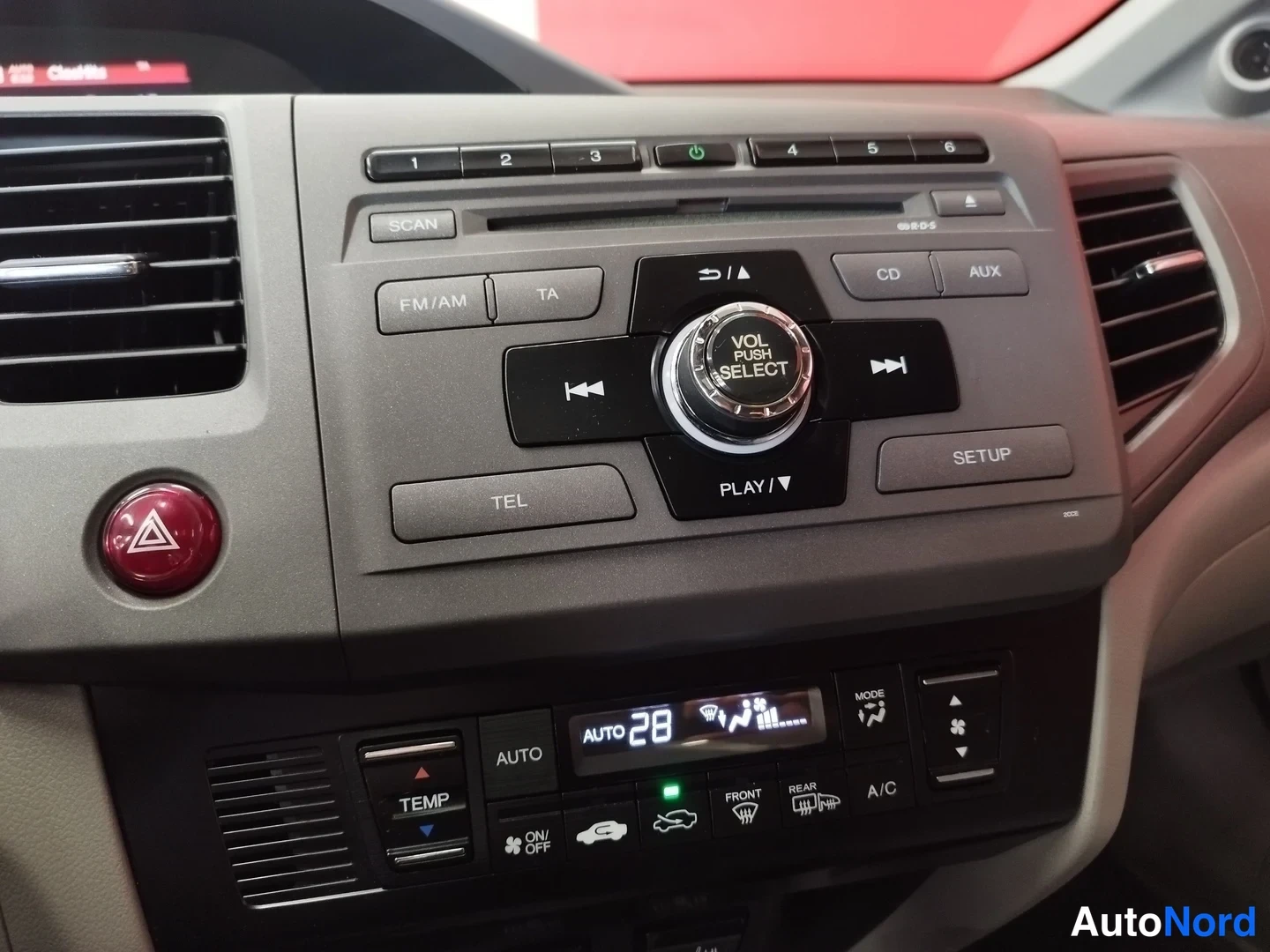 Edestä: Keskikonsolin lähikuva: radioyksikkö näppäimillä FM/AM, TA, CD ja AUX, mukana peruutuskameranäppäin sekä automaattinen kaksitoiminen ilmastointi (AUTO, TEMP, A/