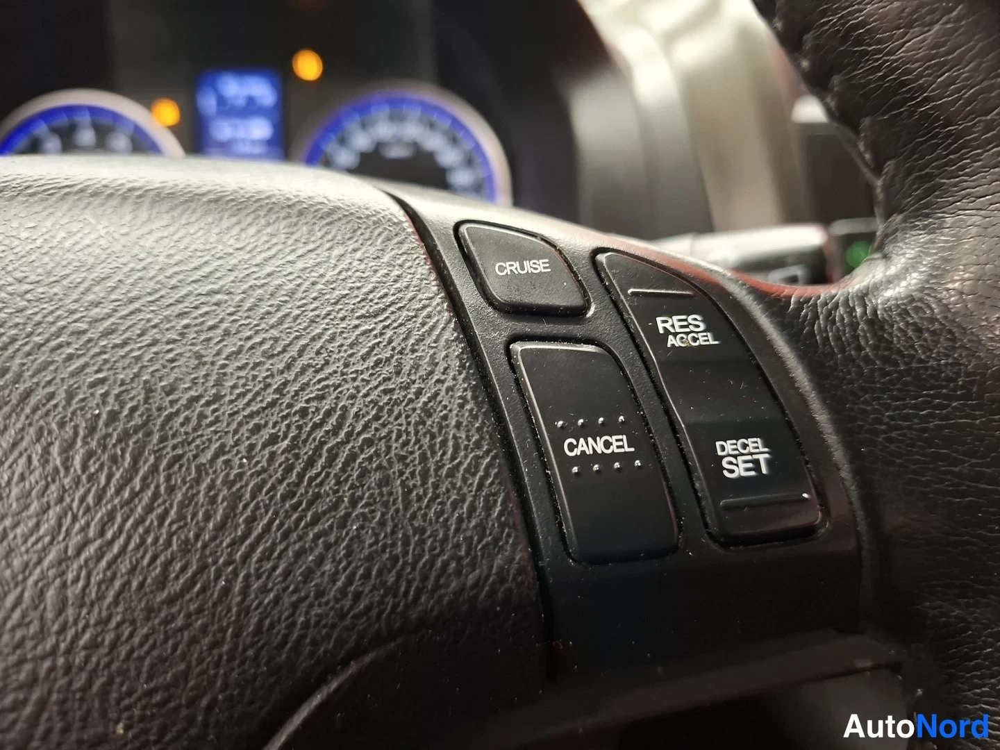 Yksityiskohta: Ohjauspyörän cruise control -näppäimet: CRUISE, CANCEL, RES ACCEL ja DECEL SET.