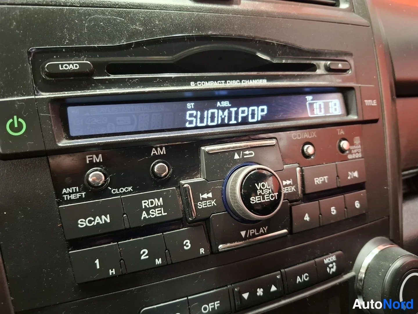 Muu: Autoradion ja 6-CD-vaihtajan hallintapaneeli: näytössä teksti SUOMIPOP ja kellonaika 10:18, painikkeet FM, AM, SCAN, RDM A.SEL, SEEk, RPT, numeronäppäimet 1–6 j