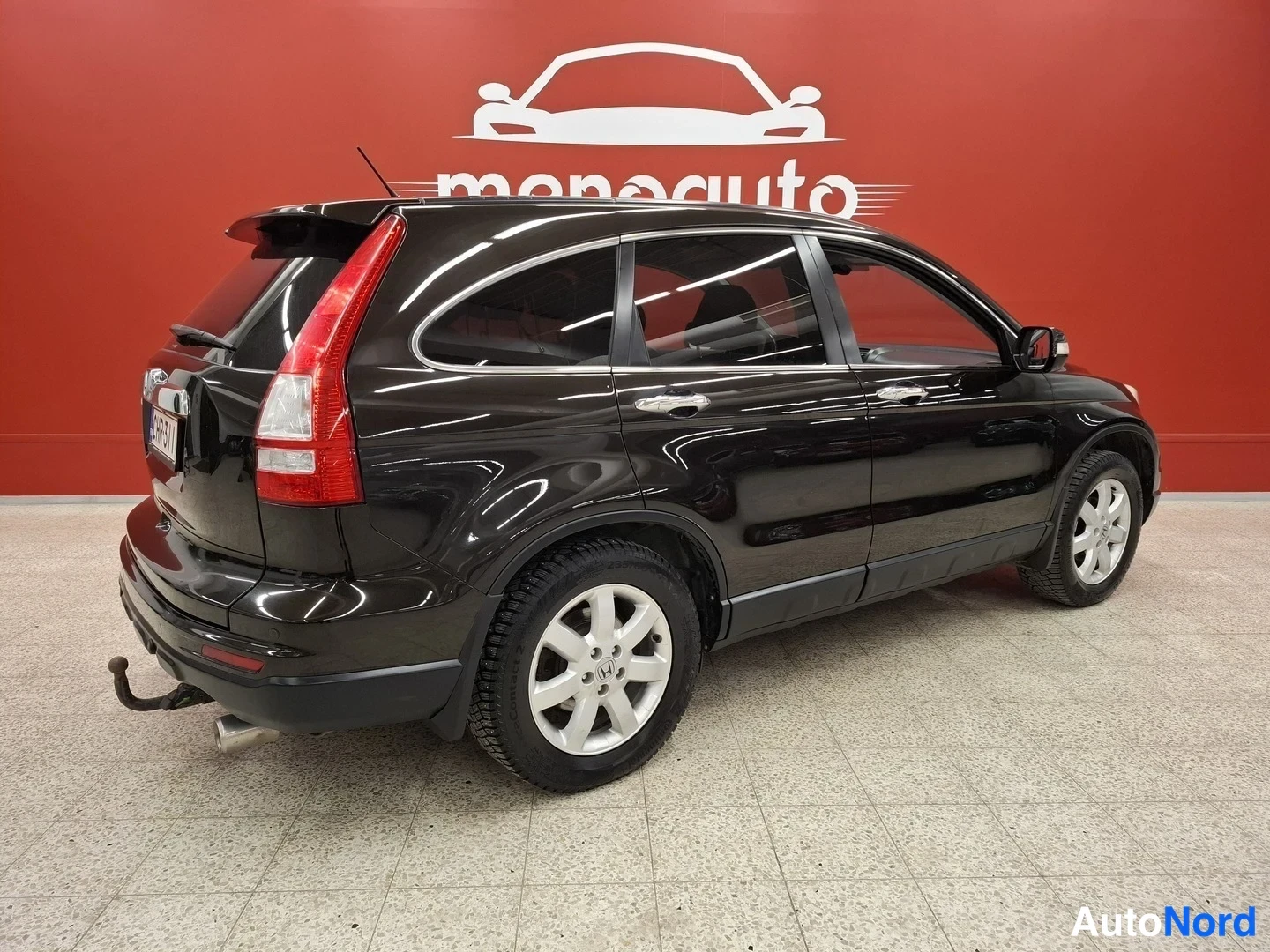 Takaviisto: Mustanruskea Honda CR-V takakulmasta kuvattuna, takavalojen ja takaosasta näkyvä kohdevalaisin T-piste takaosaan.