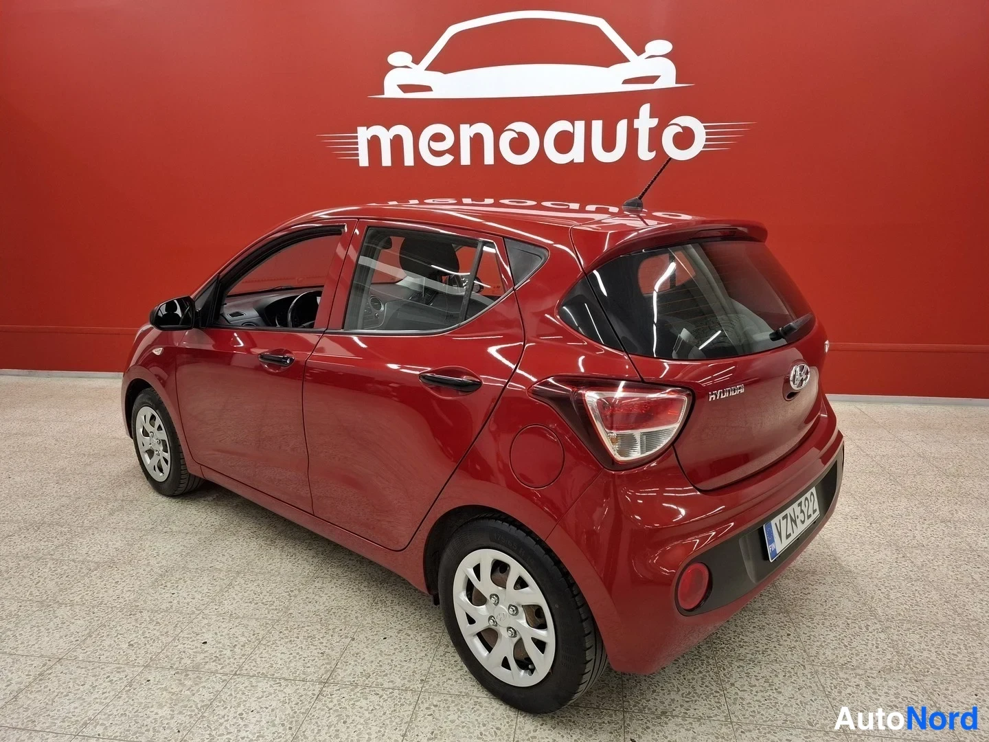 Takaviisto: Punaisen Hyundai i10:n takakolmannes sisätiloissa; rekisterikilpi lukee.