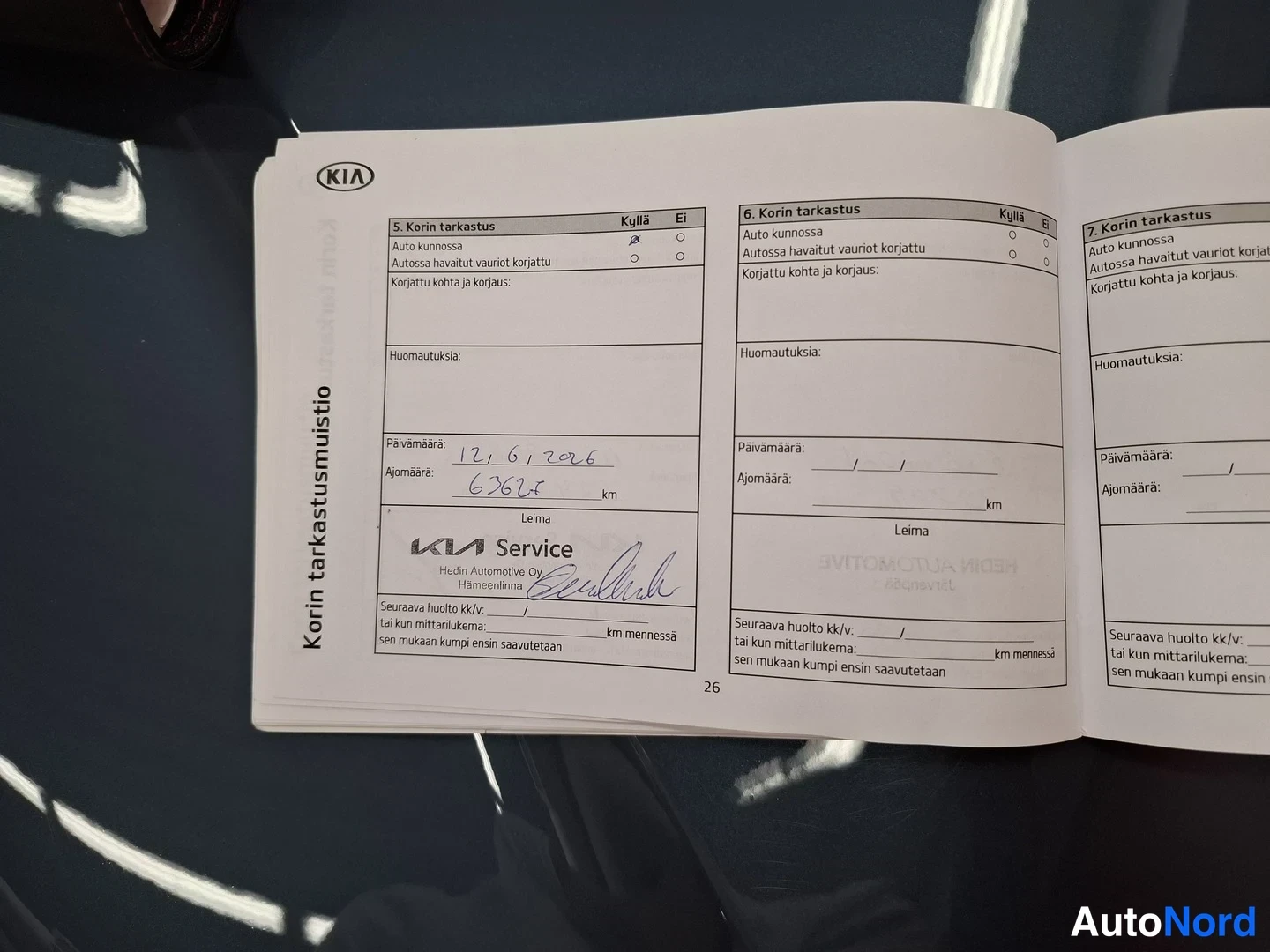 Asiakirja: Avattu Kian korin tarkastusmuistion sivu 26, jossa yksi huoltotarkastus 12.6.2026 ajomäärällä 63626 km ja KIA Service -leima Hedin Automotive Oy Hämeenlinna.