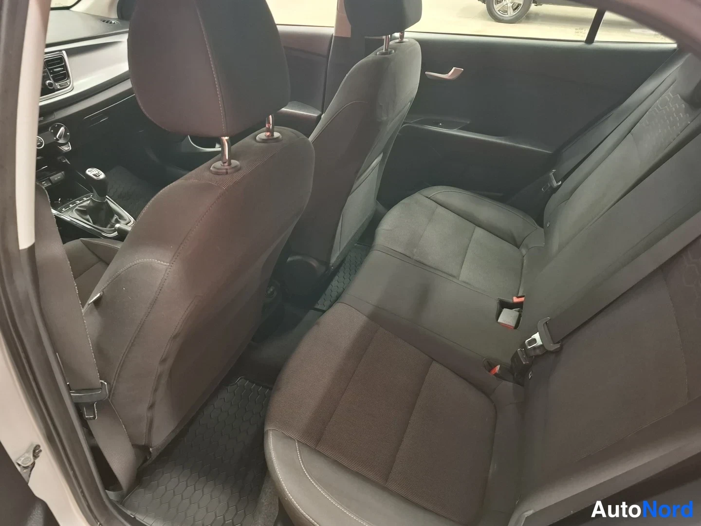 Yksityiskohta: Takaistuimet harmaata kangasta: vasen ja keskioikea istuin 50/50-ositettu, paineistuspisteet ja headrest-pultit vasemmassa.