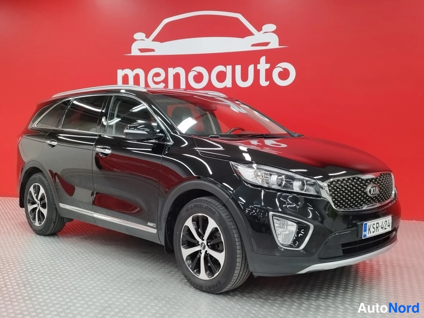 Etuviisto, nokka oikealle: Kia Sorento, musta farmarimallinen SUV esiintymisen sivukulmassa; etusäiliö, ajovalot ja kylki näkyvät punaisella taustalla.