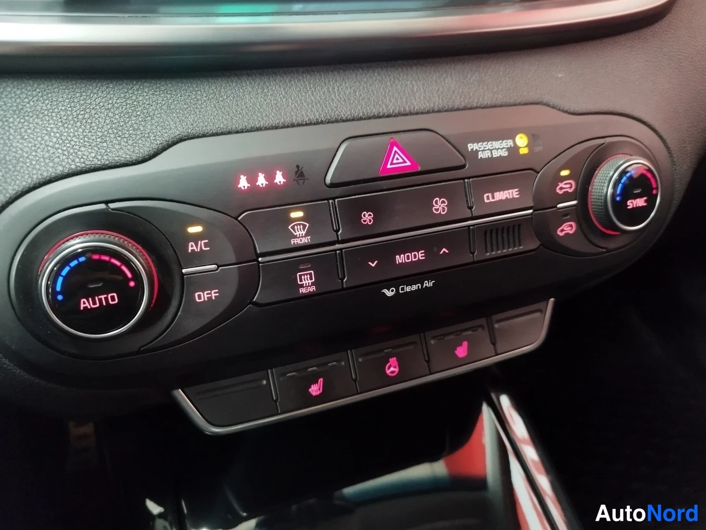 Yksityiskohta: Kaksivyöhykeilmastointipaneeli AUTO- ja SYNC-toiminnoilla, A/C, front/rear defrost, Clean Air -merkinnät ja lämmitettävien istuinten painikkeet alareunassa.