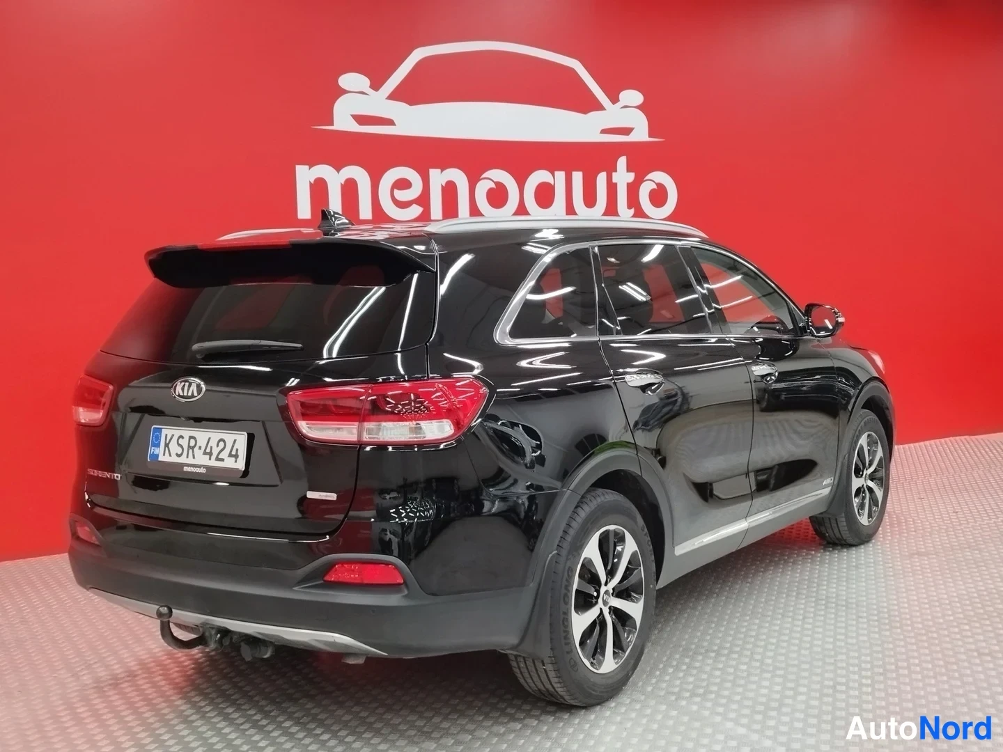 Takaviisto: Kia Sorento, musta SUV takakulmaesityksessä; takavalot, avattava takaluukku ja kylki näkyvät punaisella taustalla.