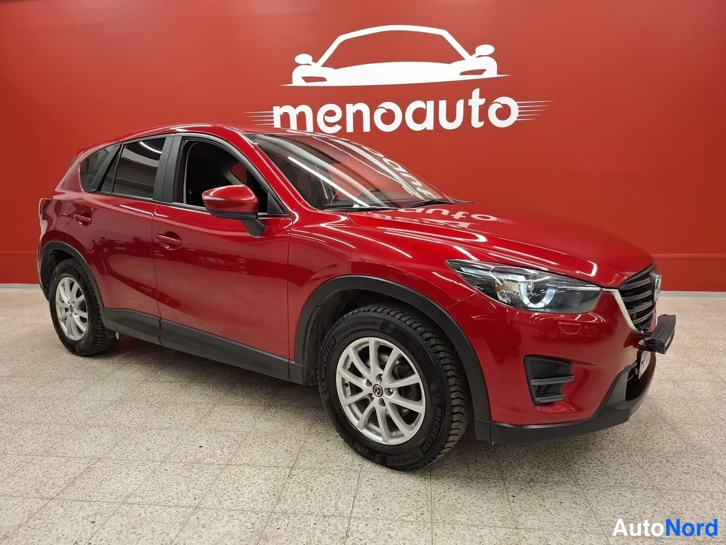 Etuviisto, nokka oikealle: Punainen Mazda CX-5 kulmittain edestä oikealta, etupansa ja oikea sivu näkyvissä.