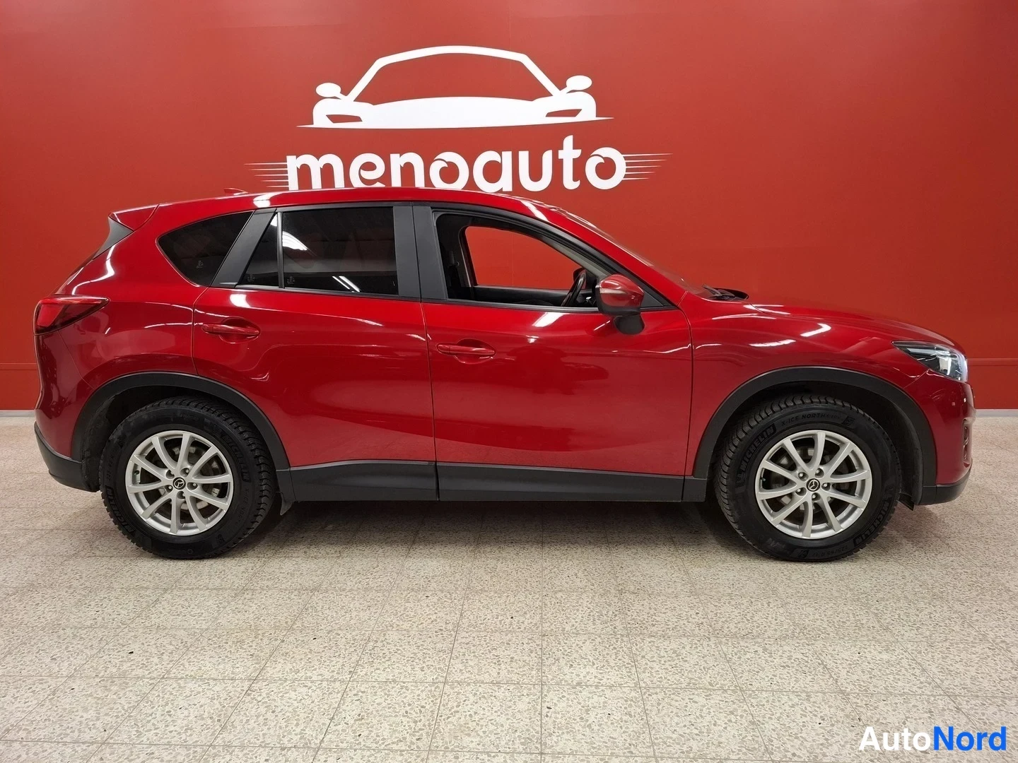 Sivulta: Punaisen Mazda CX-5:n oikea sivu, molemmat oikeanpuoleiset ovet ja pyörät näkyvissä.