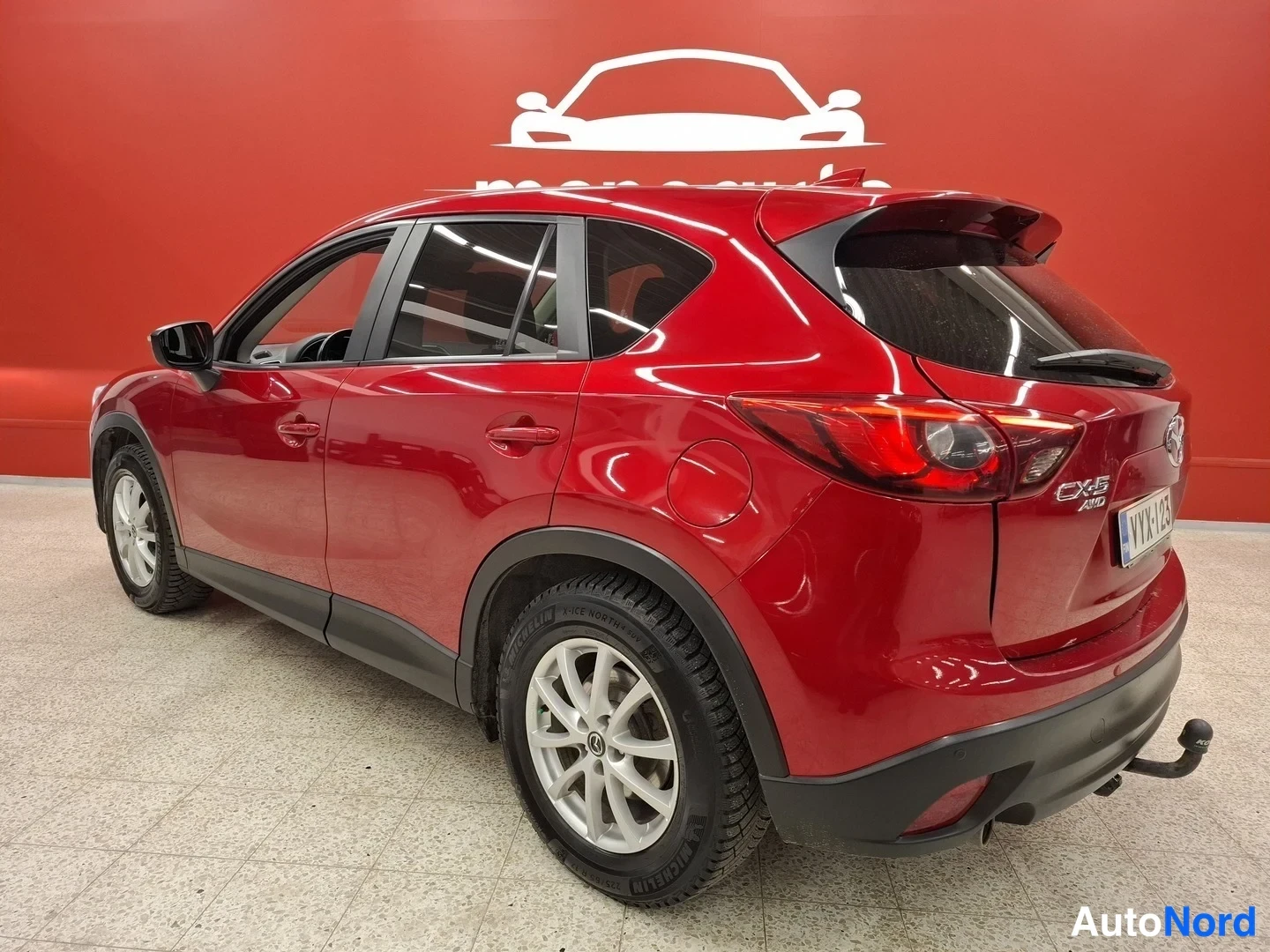 Takaviisto: Punaisen tila-auton takaosa ja kylki kuvattuna sisätiloissa, takavalot ja peräossa CX-5-merkintä näkyvät.