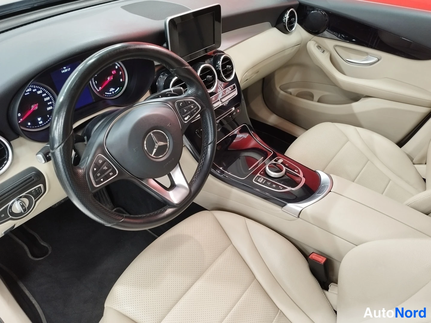 Muu: Mercedes-Benz GLC:n ohjaamo: ratin, kojelaudan ja keskinäytön näkymä beigettä sisustaa vasten.