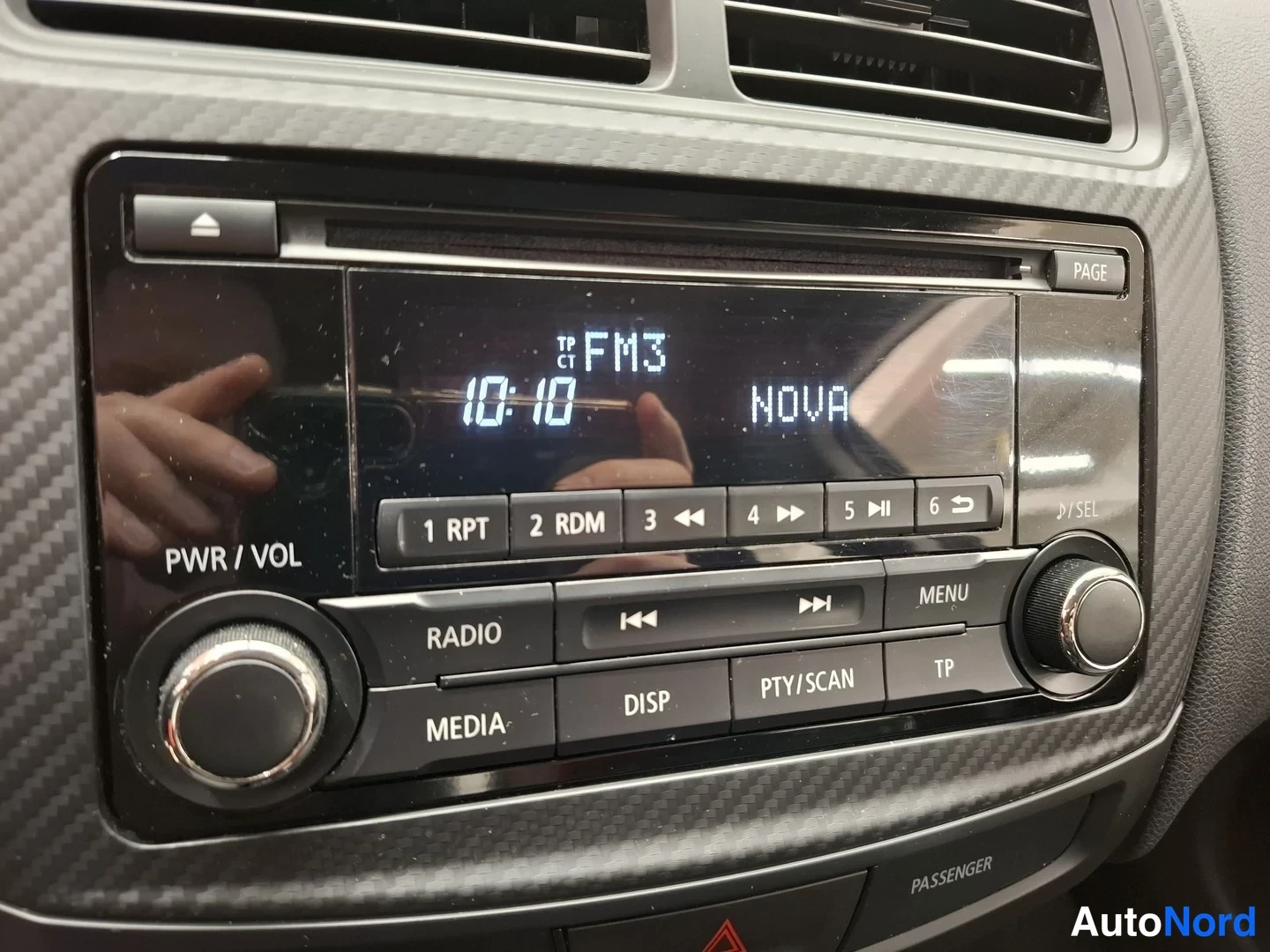 Yksityiskohta: Sisätila: radio-CD-soitin, näytöllä TP FM3, 10:10 ja NOVA, napeilla RADIO, MEDIA, DISP, PTY/SCAN, MENU, TP.