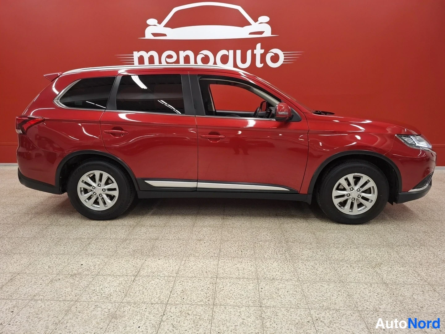 Etuviisto, nokka oikealle: Punaisen Mitsubishi Outlanderin sivukuva sisätiloissa, oikea sivu näkyy, kattohelinät ja kromilistat oviin nähden.