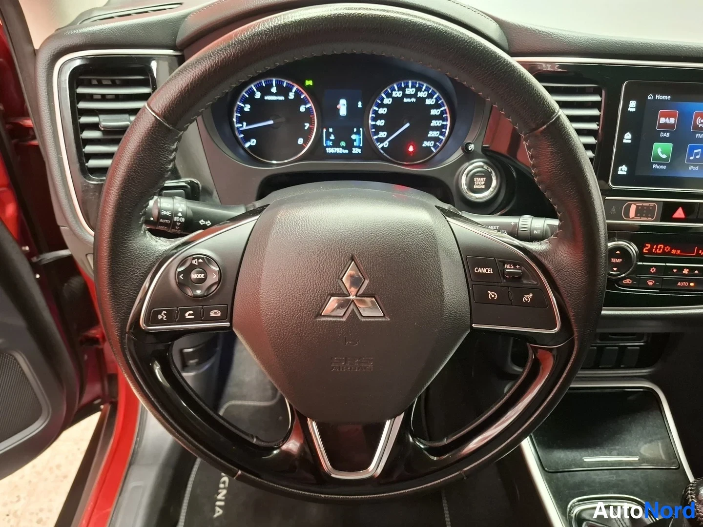 Muu: Mitsubishin merkkirattilta lähikuva, mittaristo näyttää 150718 km matkan, start/stop-painike, Bluetooth-puhelinvalikko ja audionhallinta näkyvät.