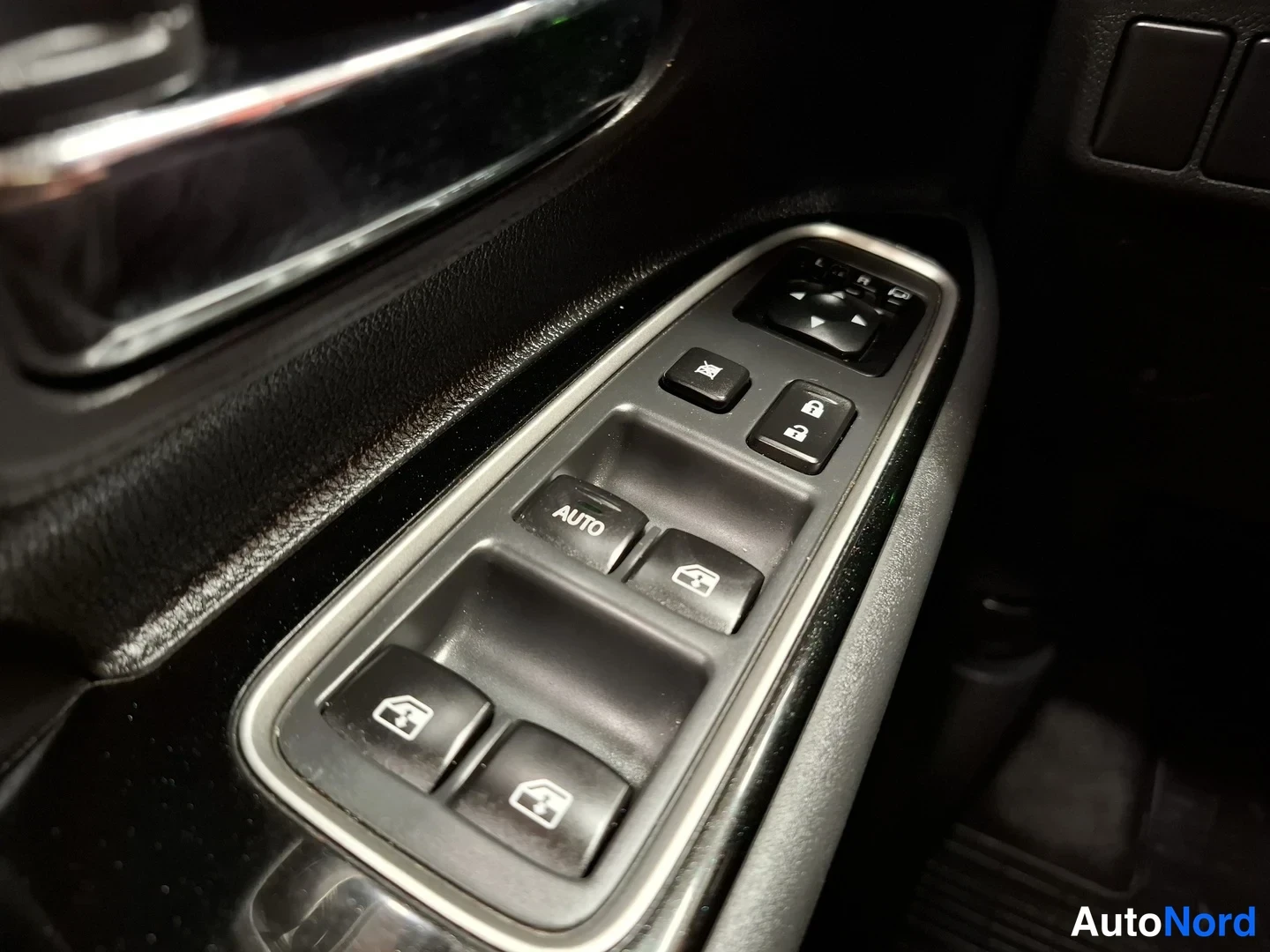 Yksityiskohta: Ohjaamon oven kytkinryhmä: neljä ikkunanostopainiketta (yksi AUTO-merkinnällä), peilinopyt kytkimet ja lukituuspainikkeet.