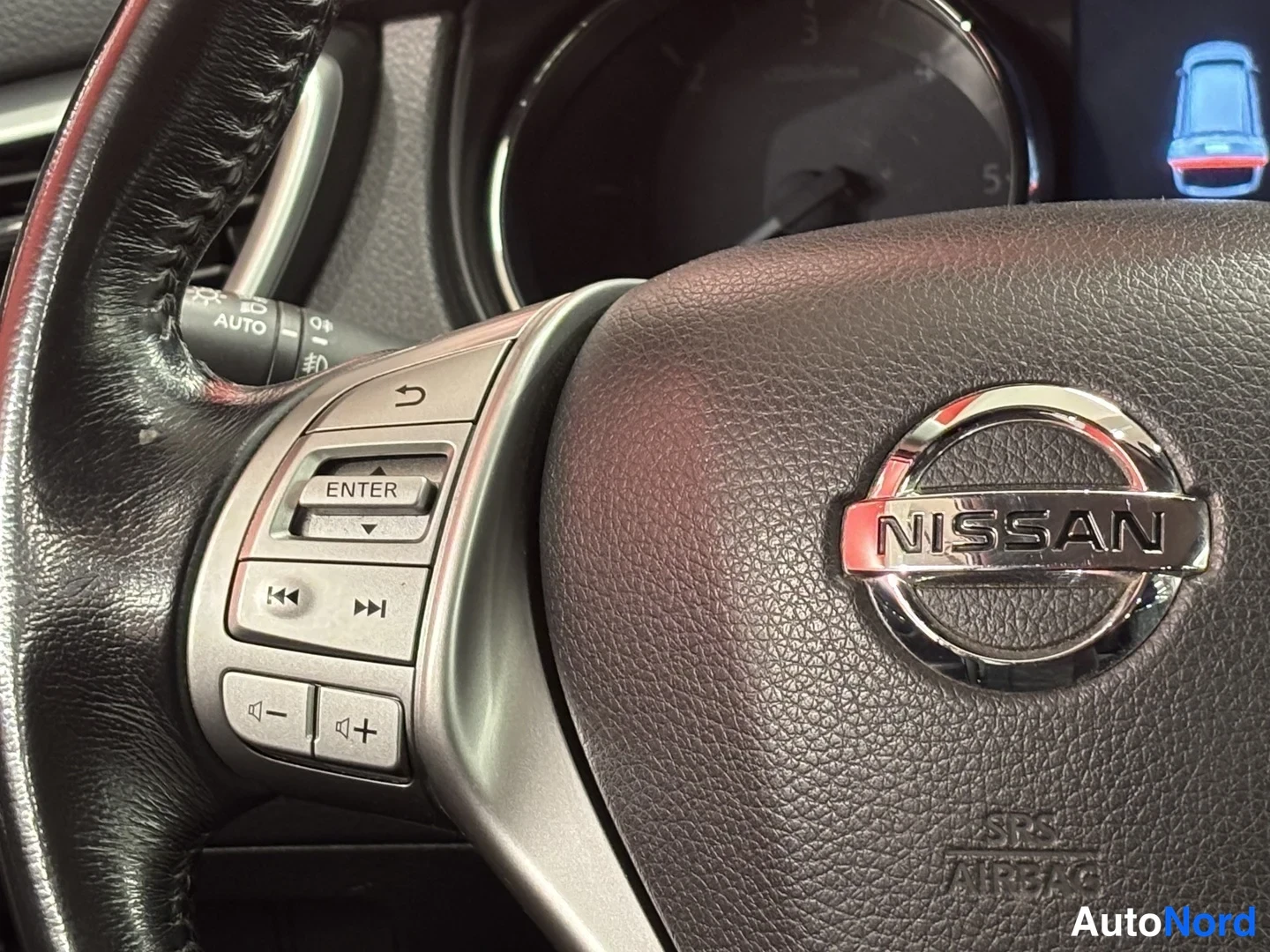 Muu: Ohjauspyörän vasen puhelin- ja ääniohjainnäppäimistö, Nissan-logo ja SRS AIRBAG-teksti kuvassa.