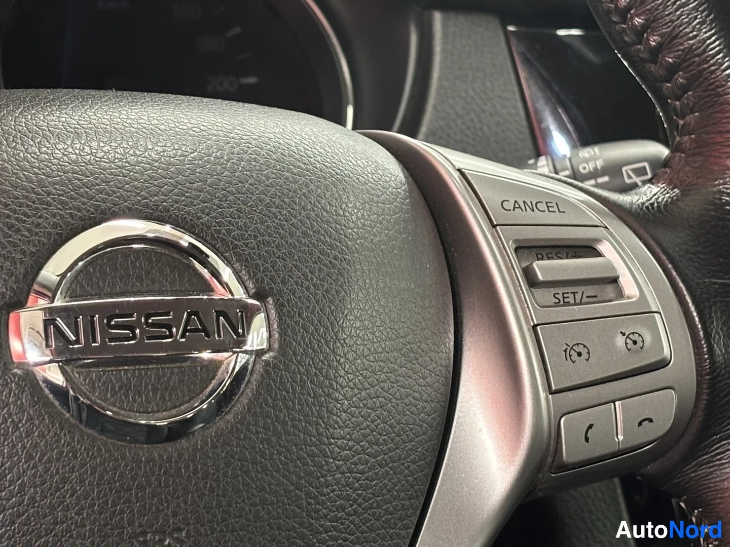 Yksityiskohta: Nissan-merkillä varustettu ohjauspyörä, jossa näkyvät vakionopeudensäädön CANCEL-, RES+- ja SET/−-painikkeet.