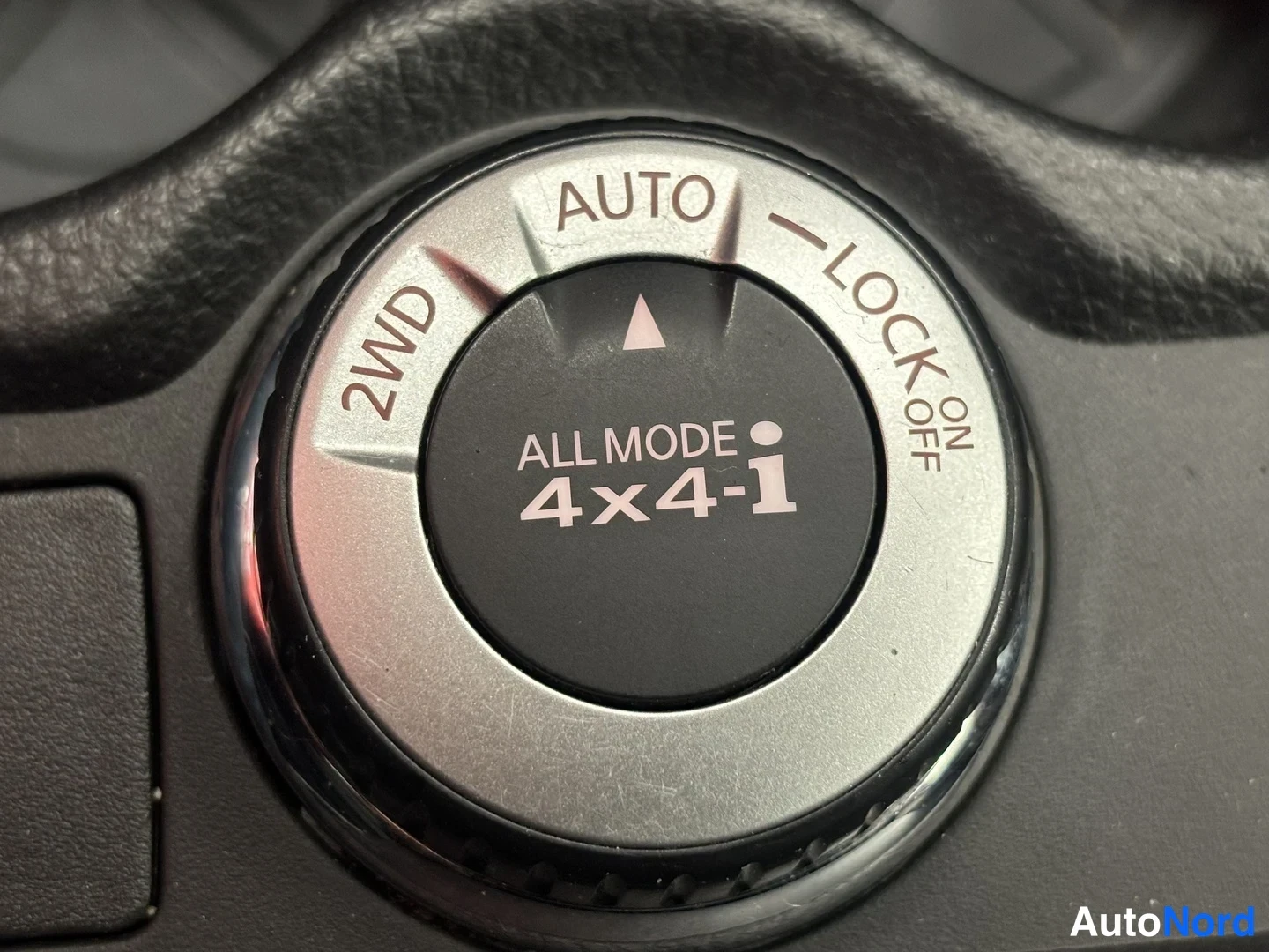 Yksityiskohta: Sisätilakuvan lähikuva:autojen nelivetovalitsin, jossa on asennat 2WD, AUTO ja LOCK ON/OFF ja tekstillä ALL MODE 4x4-i.