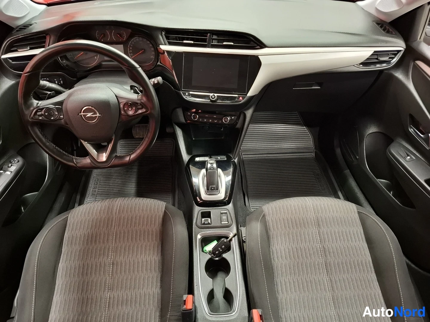 Muu: Ohjaamo ylhäältä: Opel-ohjauspyörä, kojelauta, kosketusnäyttö, automaattivaihteen valitsin ja kangasistuimet.