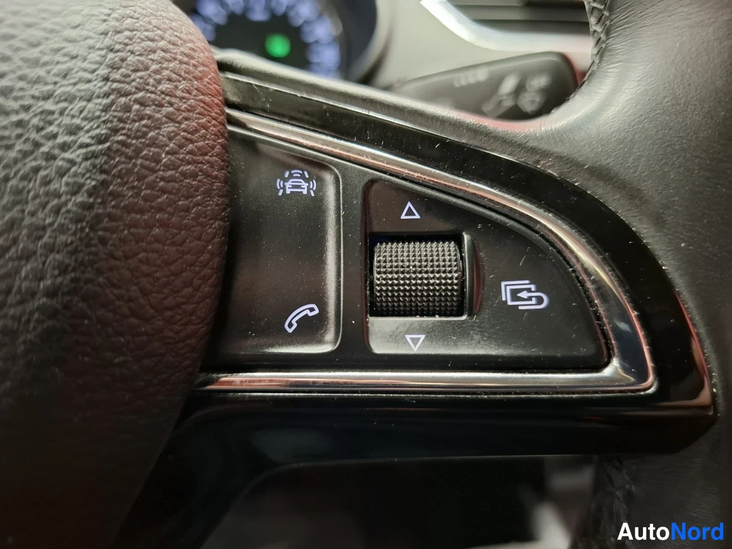 Muu: Ratin pikapainikkeet: puhelin- ja Adaptiivinen Cruise Control -symboli, säädinrulla ja vaihtopainike.