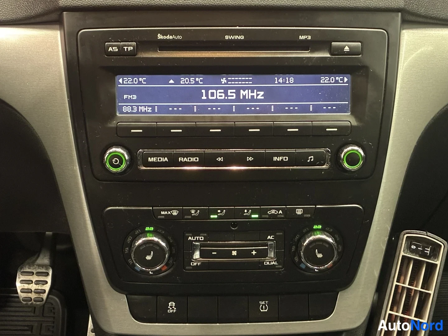 Yksityiskohta: Skoda Swing -radio ja automaattinen kaksipaikkainen ilmastointi: näyttö osoittaa 106,5 MHz ja lämpötilat 22,0 °C, säätimet AUTO, AC, OFF, DUAL ja ESP OFF -nappi