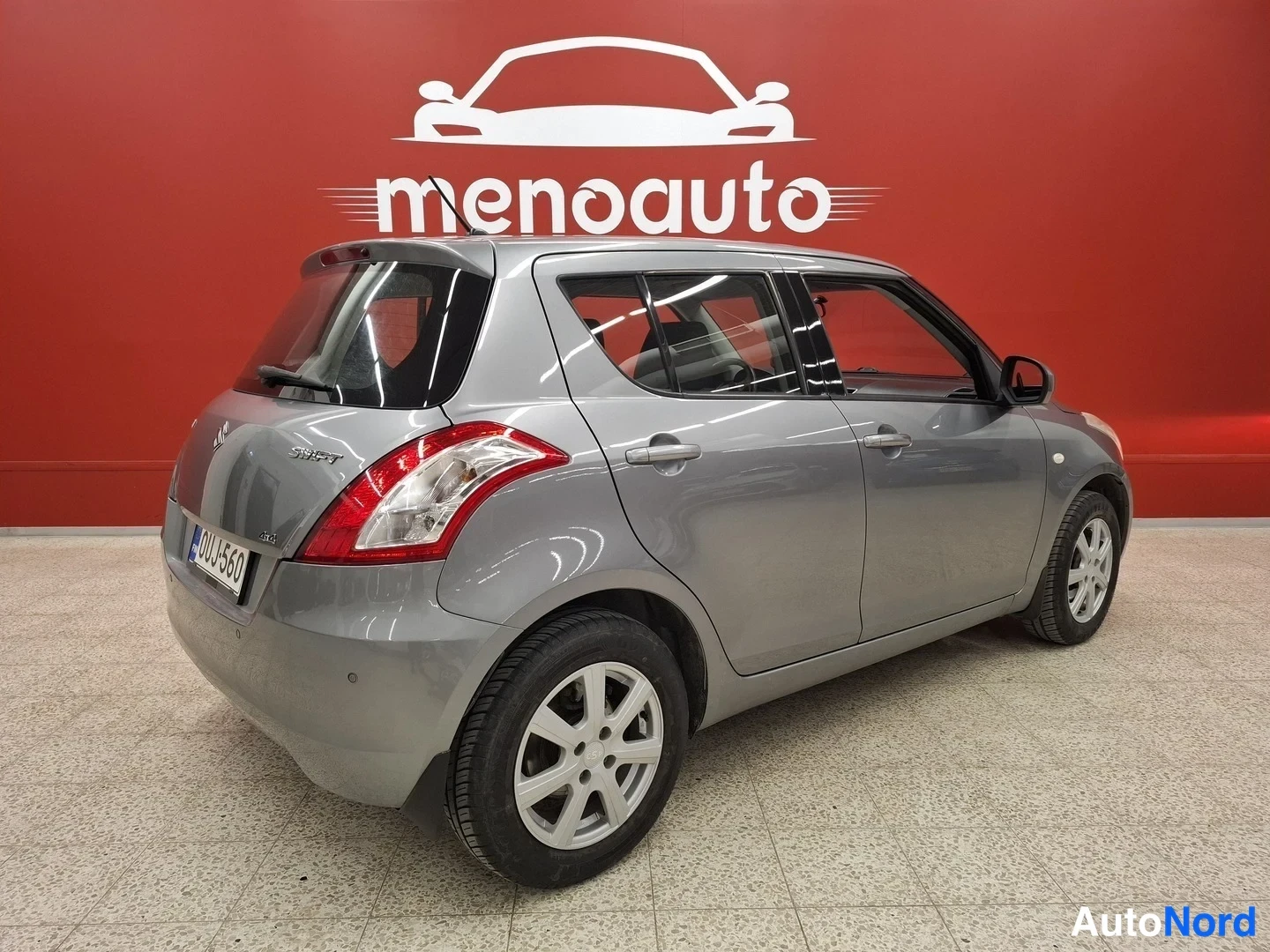 Takaviisto: Harmaa Suzuki Swift viistosti takaa vasemmalta kuvattuna sisätiloissa.