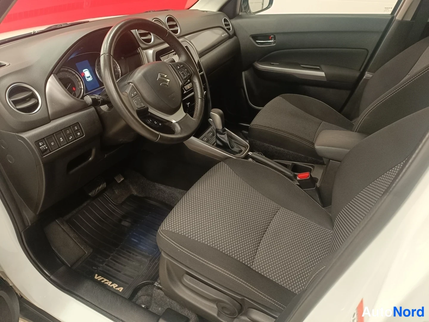 Muu: Kuljettajan puolen sisätila: Suzuki-ohjauspyörä, tummat kangasistuimet ja VITARA-tekstillä varustettu lattiamatto.
