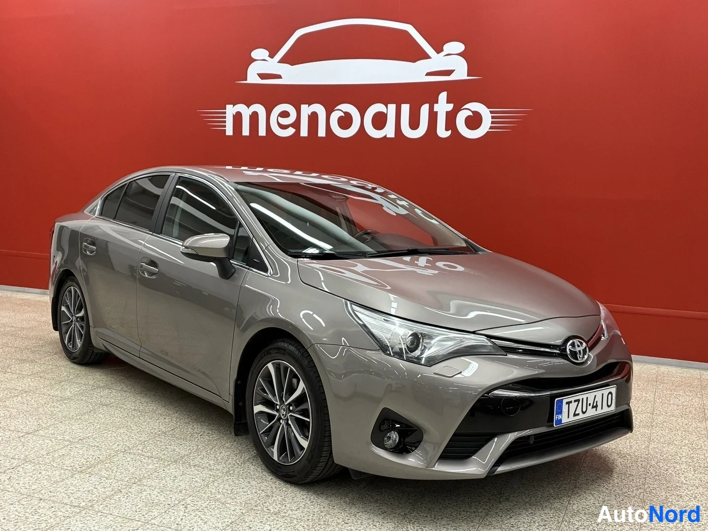 Etuviisto, nokka oikealle: Toyota Avensis -sedanin keulan kolmasosa kuvattuna oikealta, harmaa kori, rekisteri