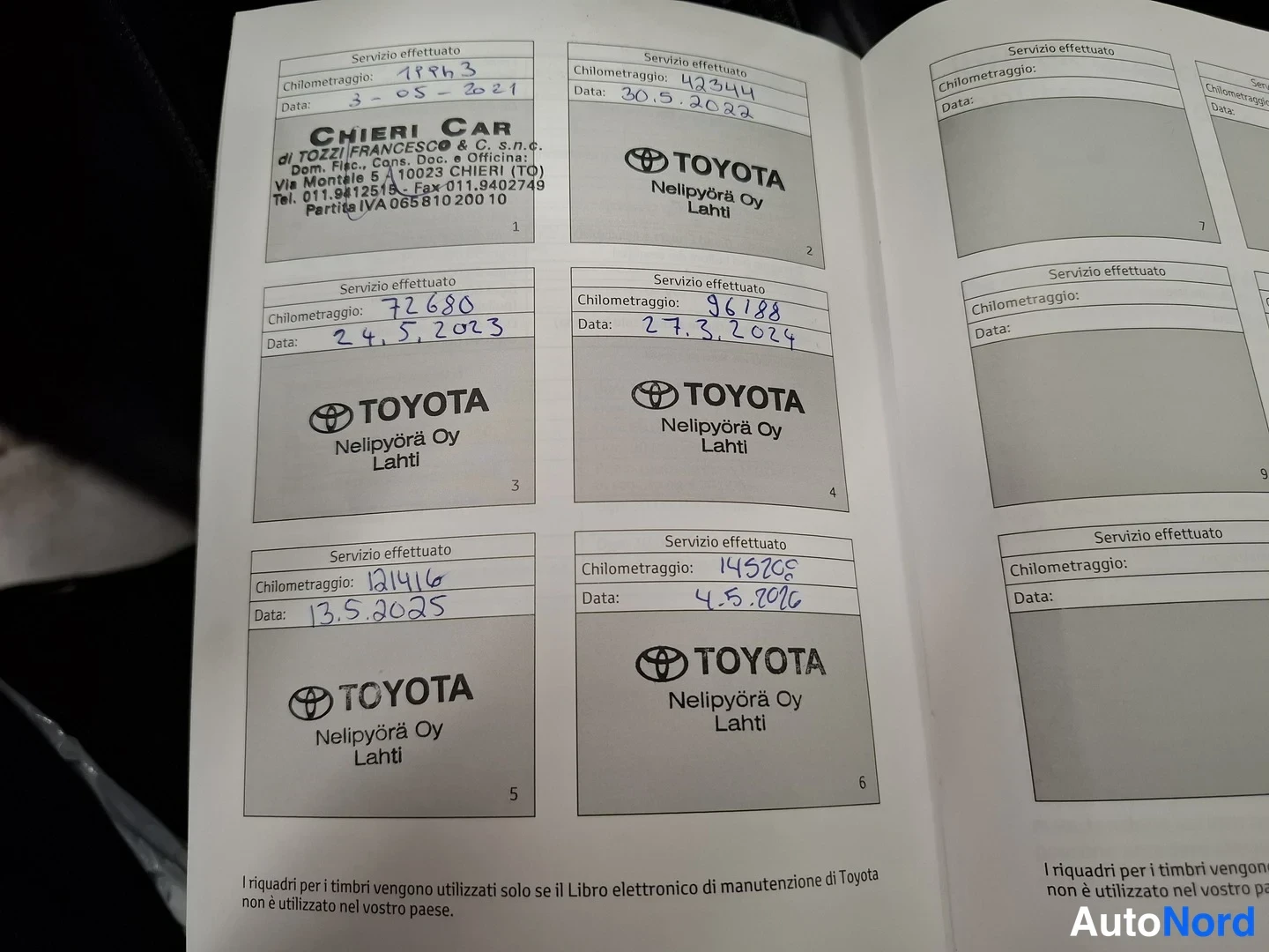 Muu: Auki avattu Toyota-huoltokirja, jossa käsinkirjoitetut huoltomerkit: kilometrit 71413, 43344, 72680, 96188, 124146 ja 145202 päivämäärineen vuosina 2021–2026.