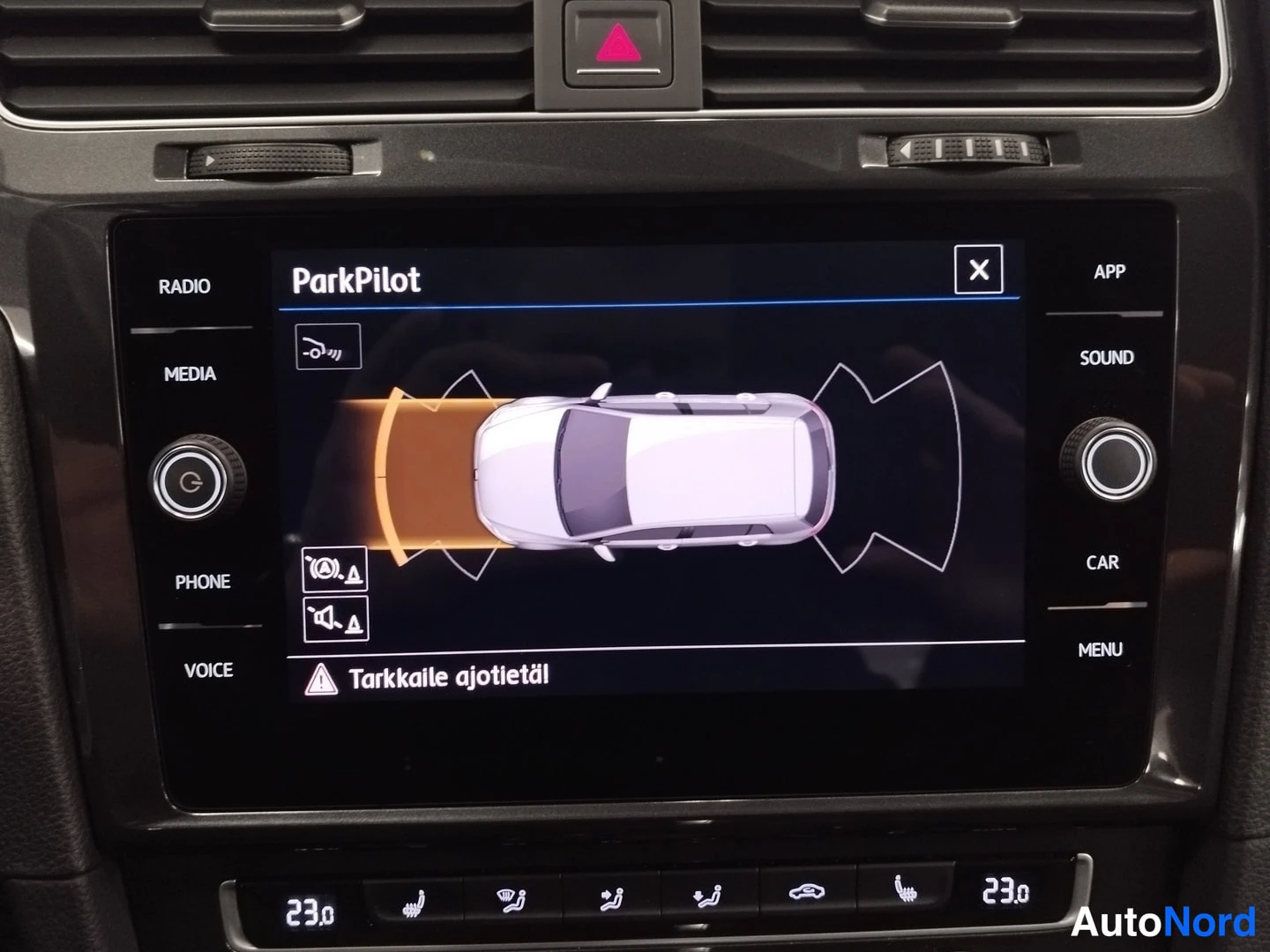 Muu: Kojelaudan infotainment-näyttö näyttää ParkPilot-tutkanäkymän, jossa auton ympärillä on etäisyyskaaret ja tekstimenu RULETTI Tarkkaile ajotietäl; ilmastointipan