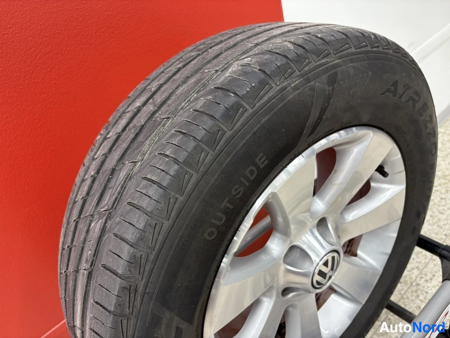 Sivulta: Kannen近kuva: musta kesärena, jossa lukee OUTSIDE, hopeanvärinen alumiinivanne ja Volkswagen-tunnus napassa.