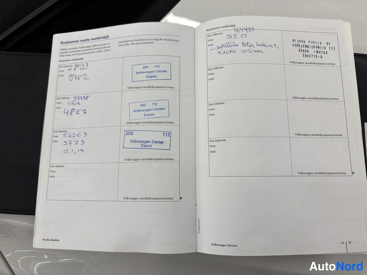 Muu: Avattu Volkswagen-huoltokirja, korjaamon muistiinpanot sivuilla 30-31, käsin kirjoitettuja km-lukemia ja Volkswagen Center Espoon leimoja, oikealla Niskan Huolt