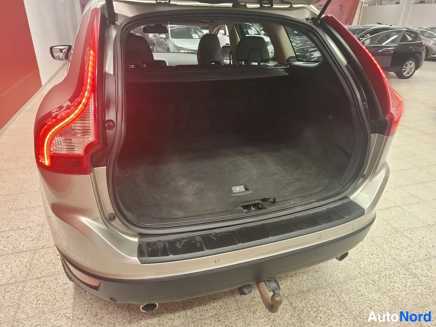 Takaa: Takaa-auki oleva Volvo XC60: tavaratilan takaa näkyvä kuva, tavaratilan suoja ja avattu takapää.