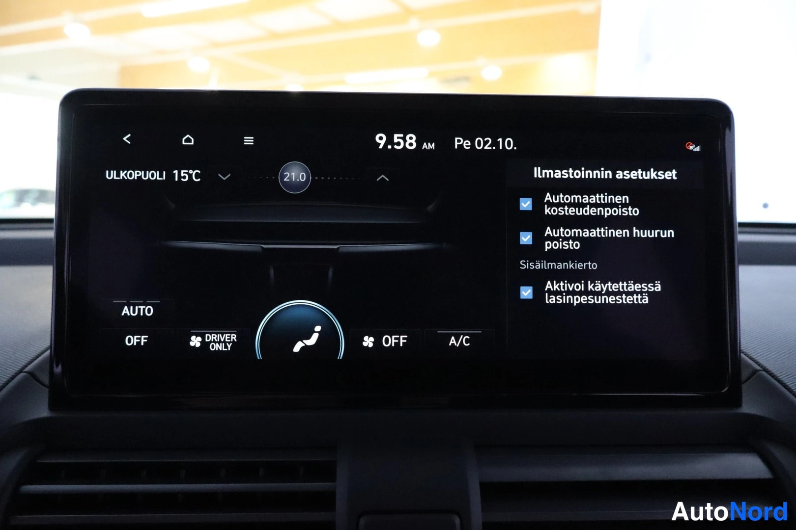 Muu: Näyttö, jossa ilmastoinnin asetukset: ulkolämpötila 15 °C ja sisälämpötila 21,0 °C.