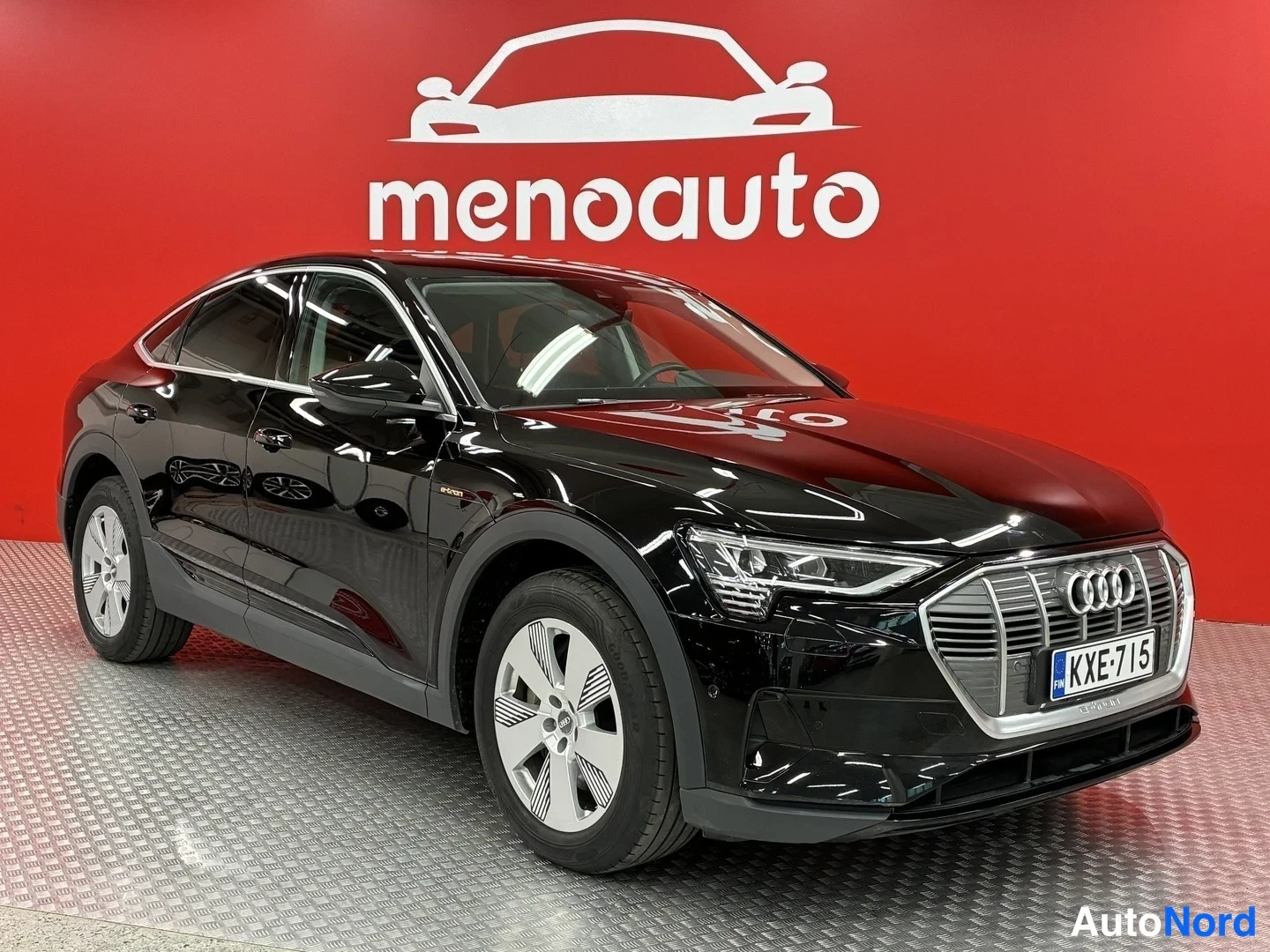 Etuviisto, nokka oikealle: Mustan Audi e-tron Sportbackin etukulma oikealta, rekisterikilpi.