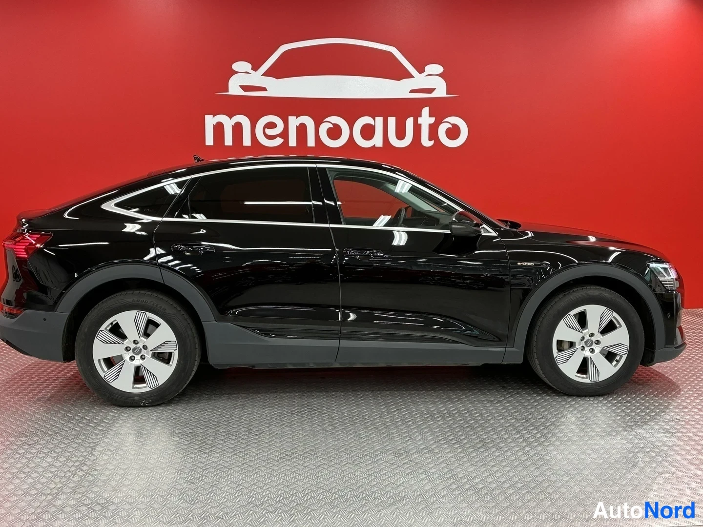 Sivulta: Mustan Audi e-tron Sportbackin sivuprofiili, auton oikea sivu.