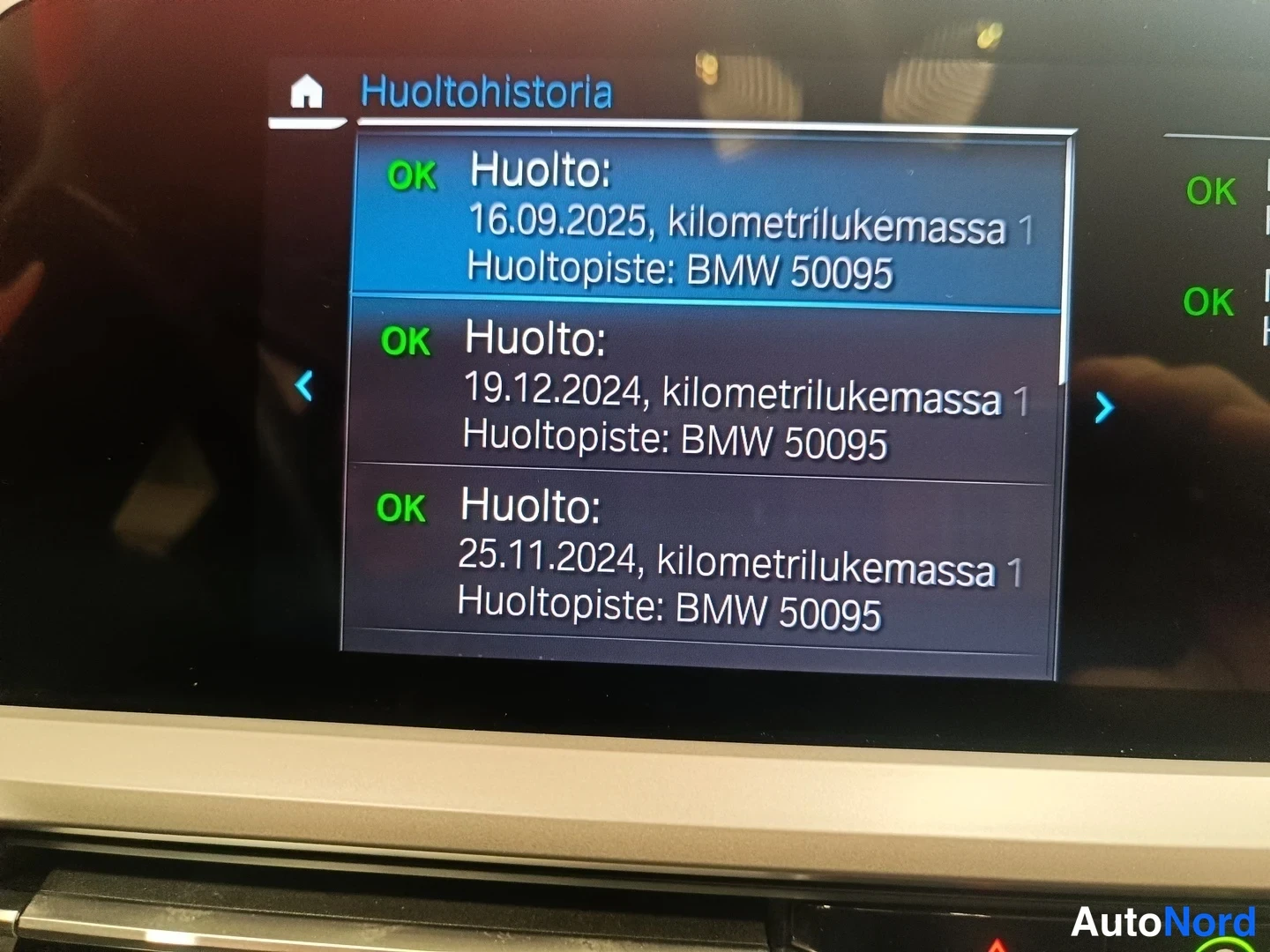 Yksityiskohta: Auton kojelaudan näyttö, jossa on Huoltohistoria-lista ja kolme huoltoa vuosilta 2024–2025.