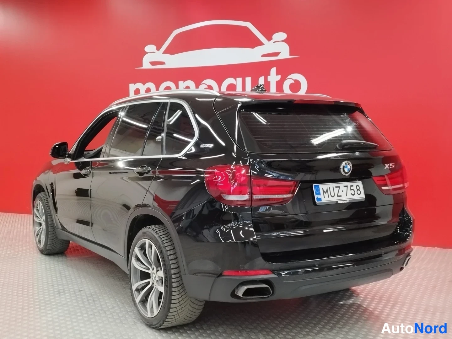 Takaa: Mustan BMW X5:n takakulma suoraan takaa, rekisterikilpi näkyy.
