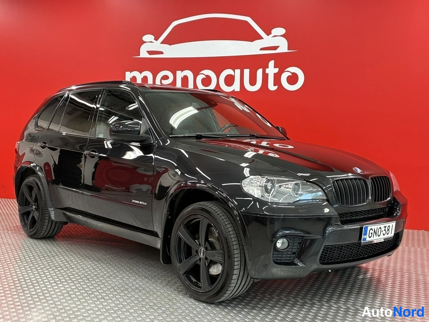 Etuviisto, nokka oikealle: Musta BMW X5 -maastoauto etu-35-kulmakuva oikealta, etusäleikkö ja mustat kevytmetallivanteet näkyvissä, rekisteritunnus.