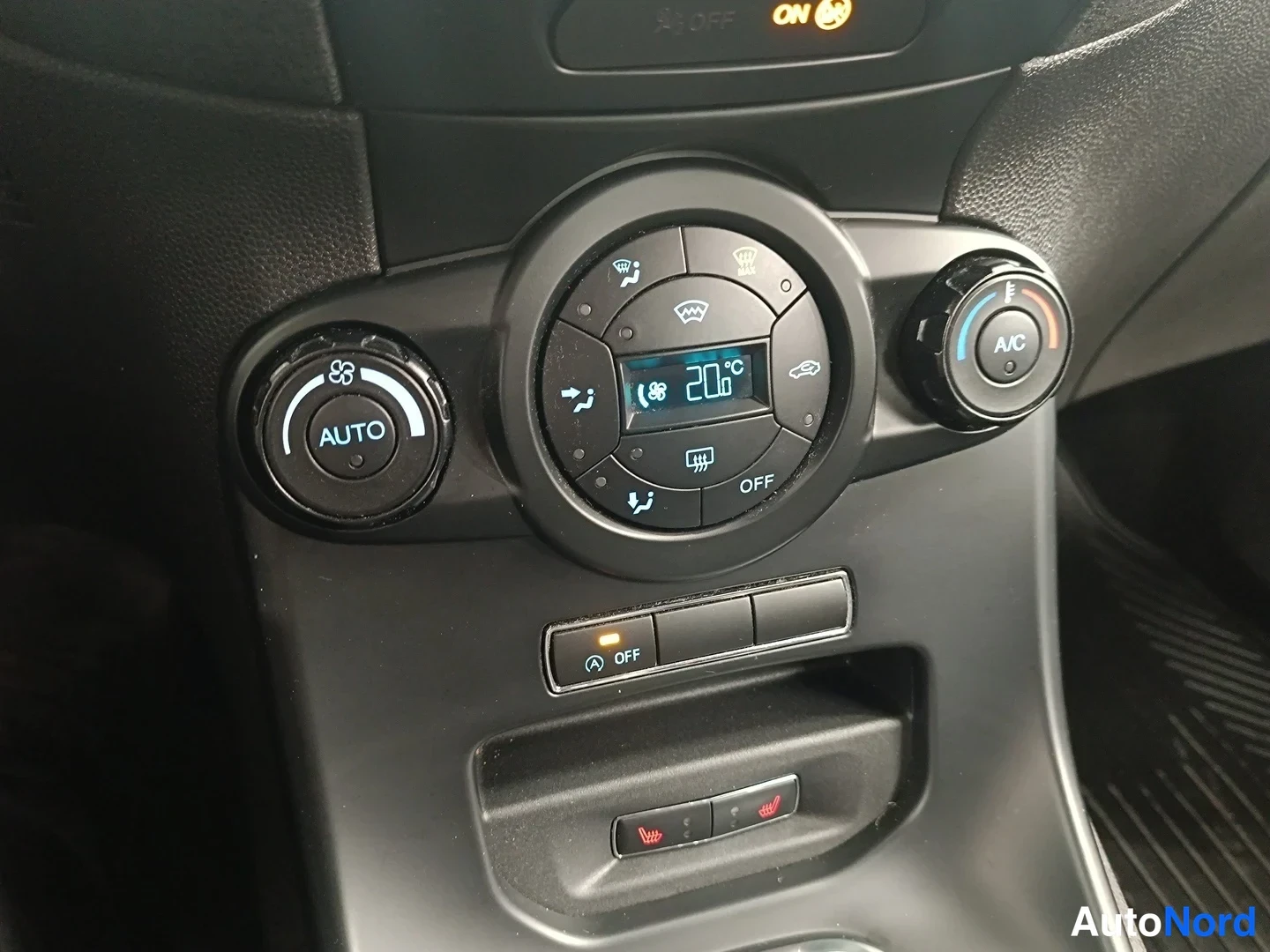 Yksityiskohta: Sisätila: keskikäyttöpöydän automaattinen ilmastointipaneeli, näytössä 20 °C, A/C- ja AUTO-säätimet, alella lämmityspainikkeet ja start/stop OFF-kytkin.