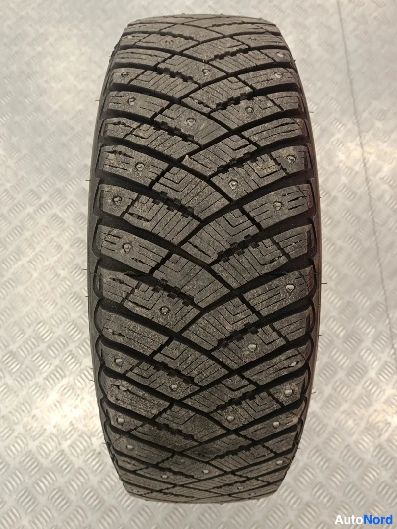 Yksityiskohta: Nastarengasta kuvaava lähi-kuva: nastoja näkyvinä pisteinä, GoodYear-merkintä silmämääräisesti, lamellit ja pohja kuvattu suorasta ylhäältä.