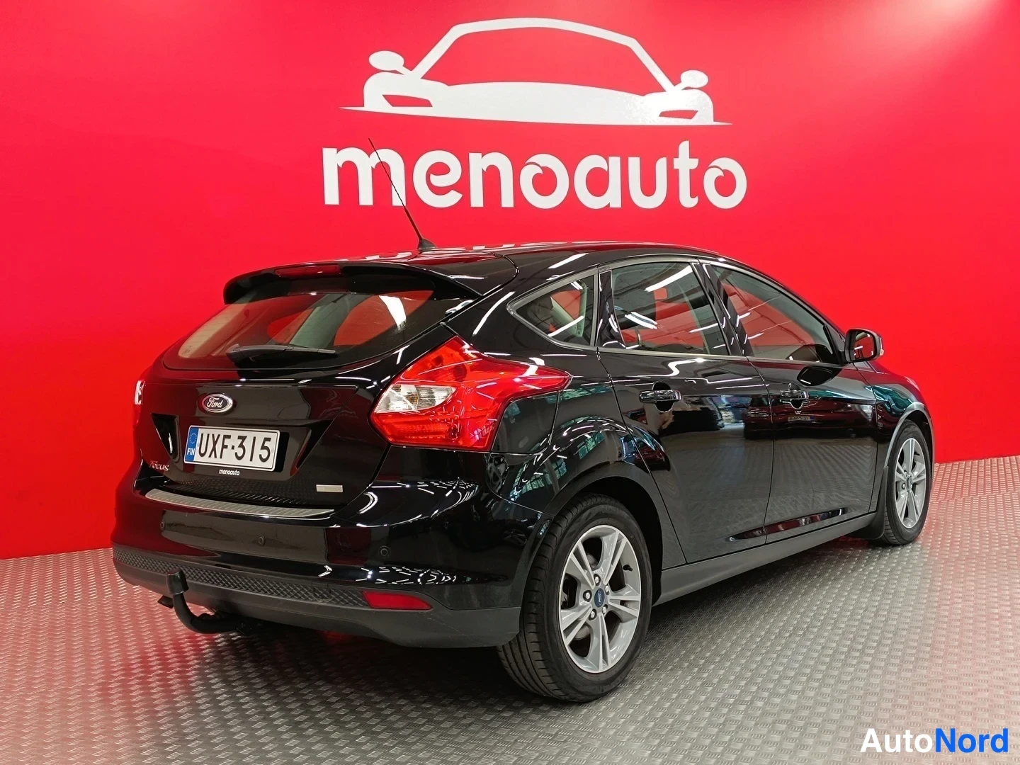Takaviisto: Mustan Ford Focus -autin takanurkkaus vasemmalta, rekisterikilpi ja punaiset takavalot näkyvissä.
