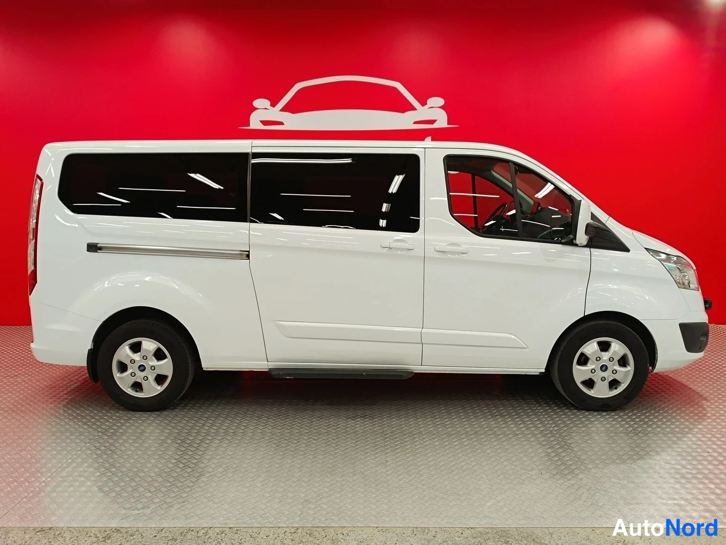 Sivulta: Ford Tourneo Custom -pakettiauto sivulta oikealta kuvattuna, oikea kylki koko pituudeltaan kuvassa.