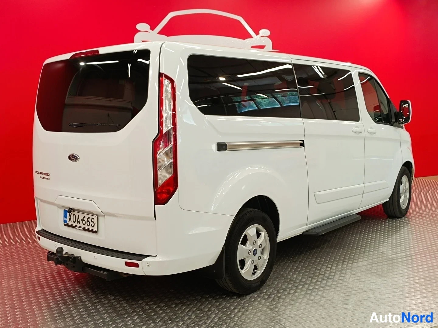 Takaviisto: Ford Tourneo Custom -pakettiauto takaa vasemmalta kuvattuna, perä ja vasen kylki näkyvät.