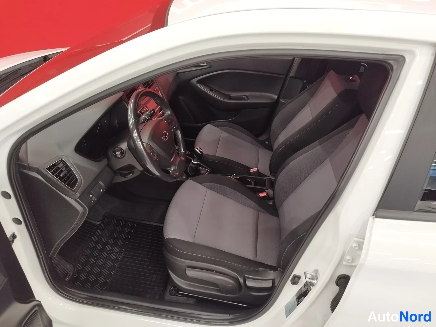 Muu: Hyundai i20:n etuistuimet ja kojelauta avatusta ovasta katsottuna.