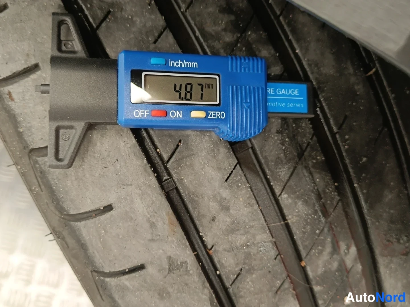 Yksityiskohta: Renkaan urasyvyys mitattu mittalaitteella: 4,87 mm.