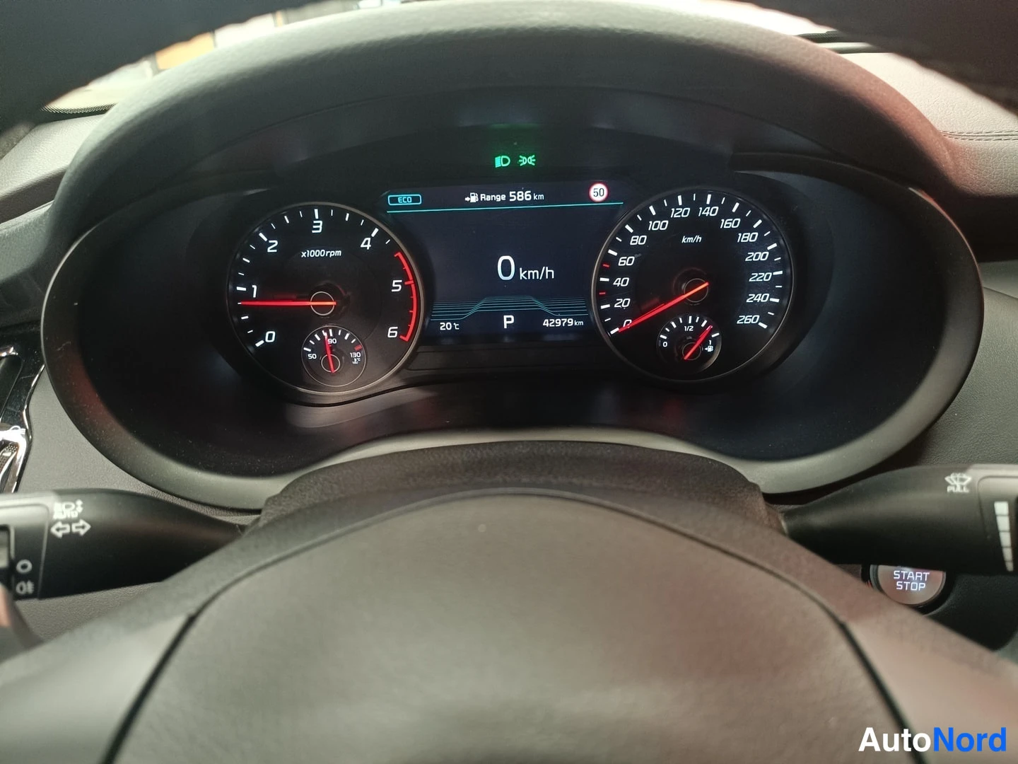 Muu: Kia Stinger: kuljettajan näköala kojelautaan. Mittaristö näyttää 0 km/h, vaihde P, odometeri 42979 km, toimintamatka 586 km ja ulkolämpötila 20 °C.