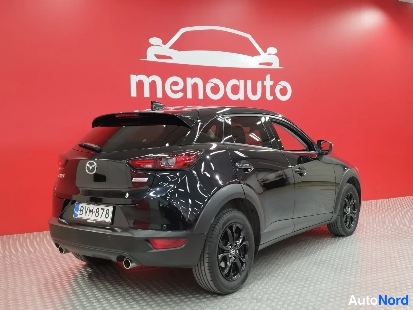 Takaviisto: Musta Mazda CX-3 takakulmasta kuvattuna, rekisteri, kaksoispakoputki näkyvissä.